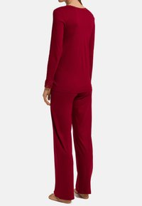 Set di pigiama a due pezzi rosso realizzato in morbido tessuto, caratterizzato da maniche lunghe con orlo in pizzo all'hem e al colletto, progettato per una vestibilità comoda.
