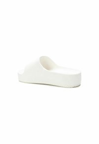 Zapato de sandalia blanca sin hebillas con una textura suave, suela de plataforma baja y diseño superior redondeado que presenta una punta abierta y un estilo sin talón.