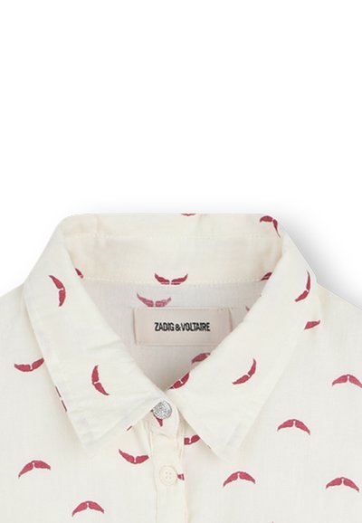 Chemise blanche avec un imprimé répétitif de lèvres rouges, boutonnière à l'avant et col classique. Présente un petit bouton en argent au niveau du col.