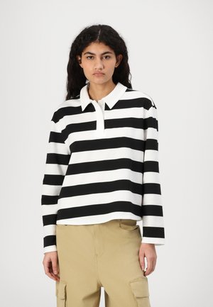 Black and white striped long-sleeve polo shirt with a folded collar, featuring a relaxed fit and visible stitching details.