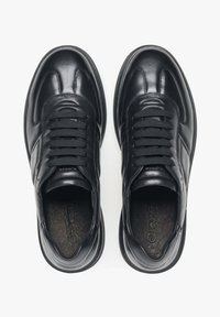 Černé kožené tenisky s hladkým povrchem, zaoblenou špičkou, polstrovaným límcem a šesti očky na tkaničky. Texturovaná podšívka.