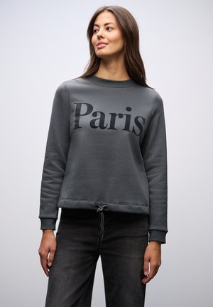 Sweatshirt gris avec "Paris" imprimé en noir, col rond côtelé, manches longues et ourlet à cordon de serrage. Tissu doux avec une finition texturée.