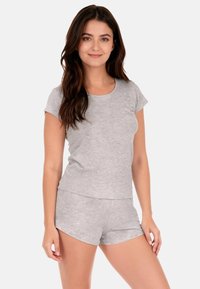 Top gris de algodón de manga corta con escote redondeado, combinado con pantalones cortos grises a juego que presentan un ajuste relajado y un dobladillo sencillo.