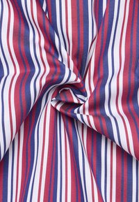 Tessuto multicolore con strisce verticali strette in rosso, blu e bianco. Il materiale ha una texture liscia e un aspetto simile al cotone.