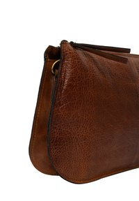 Sac à main en cuir marron avec une finition texturée, de forme arrondie et une fermeture à glissière. Il présente un accent avec une boucle en métal doré.