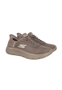 Zapatillas deportivas de ante gris con punta redonda, suela elevada y cordones, que presentan un logotipo destacado en el lateral y una suela de goma de textura suave.