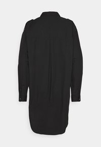 Robe-chemise noire à manches longues avec poignets boutonnés et épaulettes sur les épaules, vue de dos sur un fond uni.