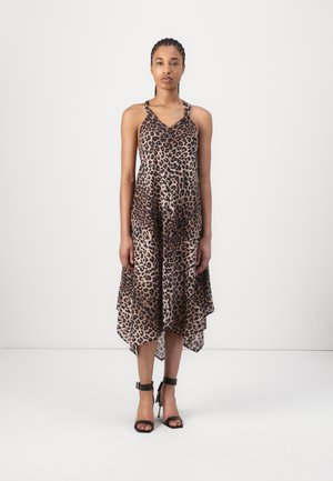 Dresses with leopard print and loose fit, featuring a V-neckline and high-low hem. The fabric looks light and silky. Black heels with ankle straps.
