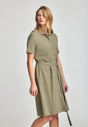 Khaki shirt dress with a collar, short sleeves, buttons down the front, and a matching belt at the waist. Smooth, lightweight fabric.