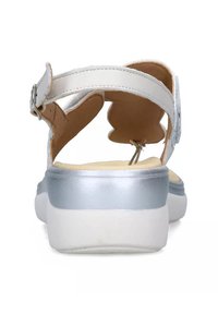 Sandalo in pelle bianca con cinturino alla caviglia regolabile, accentuato da un tacco argento, soletta imbottita e suola in gomma. La vista posteriore mette in evidenza i dettagli del design.