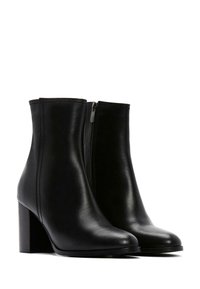 Black leather ankle boots with a smooth finish, rounded toe, and a side zipper, featuring a stacked heel and seamless design.