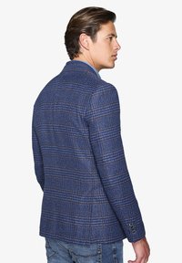 Blå ternet blazer med en struktureret design, tekstureret stof og klippede revers. Har tre-knap manchetter og en skræddersyet pasform.