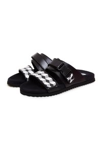 Schwarze Sandalen mit zwei dicken Riemen, die ein geometrisches Muster in Grau und Weiß aufweisen. Weiche, strukturierte Sohle, robuste Konstruktion und Schnallendetails.