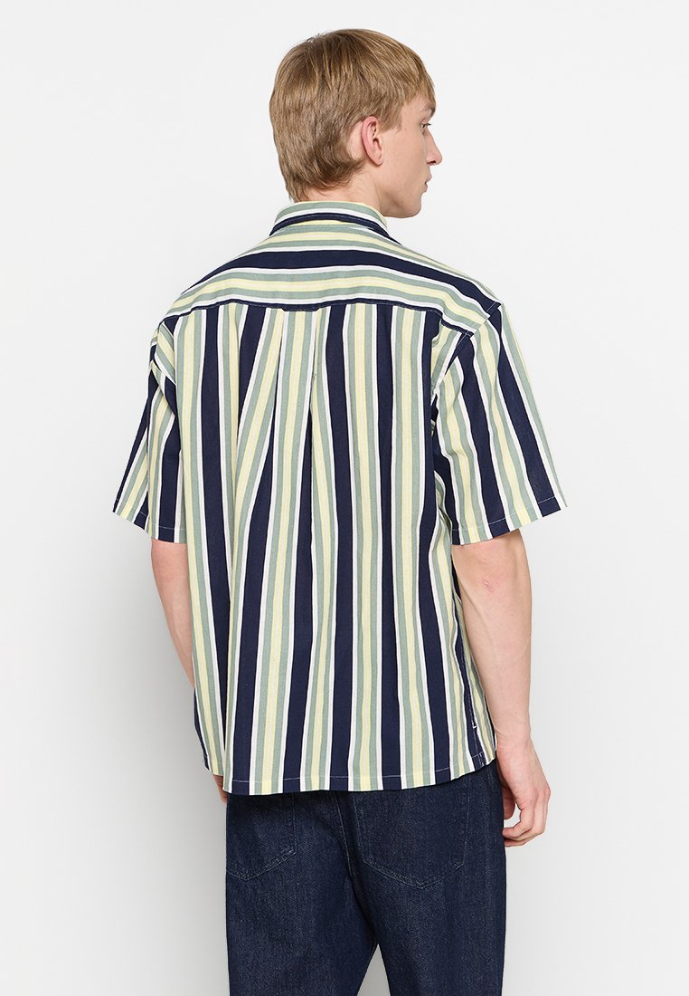 Kurzarmhemd mit vertikalen Streifen in Marineblau, Grün und Cremefarben. Locker geschnitten mit einem Rückenpasse und geradem Saum.