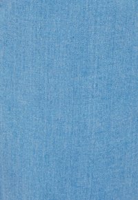 Tela de denim azul claro con una textura suave, que presenta un patrón de sarga diagonal. El material parece duradero con un acabado suave.