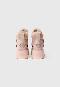 Para jasno r�óżowych botków na platformie z puszystymi kołnierzami, z logo Buffalo na piętach i paskach, przedstawionych od tyłu na białym tle.