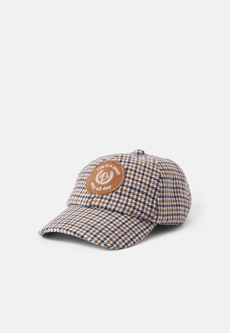 Beige och brun rutig basebollkeps med en böjd skärm, med en rund brun lapp med vit text och dekorativa lagerblad. 