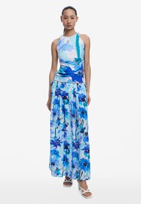 Rochie maximalistă florală în nuanțe de albastru și alb, cu guler halter, talie strânsă și fustă fluidă cu un model asemănător acuarelei.