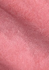 Tissu en éponge rose doux avec une surface texturée, présentant un éclat subtil et une construction à boucles denses.