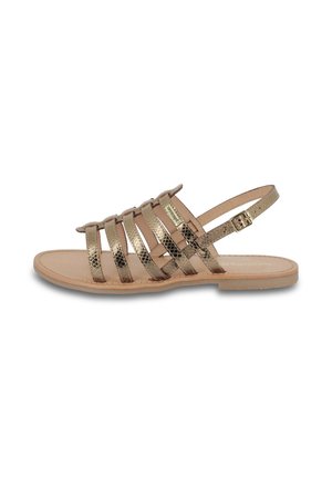 Damesandaler med flad sål med metalliske guld teksturerede stropper og en justerbar ankelspænde på en tan sål.