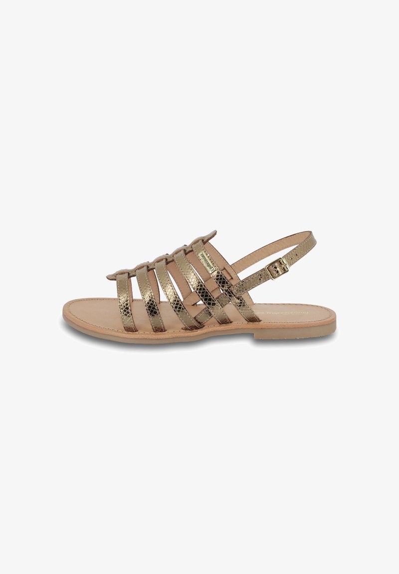 Dames platte sandaal met metallic gouden gestructureerde bandjes en een verstelbare enkelgesp op een beige zool.