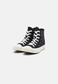 Sneakers alte in tela nera con suole in gomma bianca. Presentano ricami a ciliegia rossa e lacci bianchi. Design della punta piatta e rotonda.