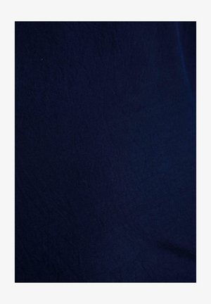 Tamnoplava tkanina s nježnim naborima i suptilnom teksturom, ravnomjerno osvijetljena bez ikakvih drugih predmeta ili detalja u vidu.