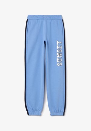 Pantalones de chándal azul claro con rayas negras a los lados. Cintura elástica y tobillos ajustados. "SUNSET" impreso verticalmente en blanco en la pierna izquierda.