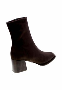 Stivaletto in suede marrone con punta affusolata e tacco a blocco. Presenta una cerniera e una texture liscia. Il tacco ha un motivo a righe.