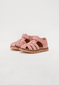 Rosa lädersandaler med flera öppna remmar, justerbar rem och en strukturerad brun sula. Utformade för komfort och andningsförmåga.