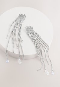 Silver-tone earrings featuring cascading rows of small rhinestones with dangling crystal accents, creating a layered and textured design.