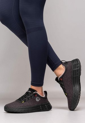 Baskets de sport grises et noires avec une tige texturée, bout rond, profil bas et œillets colorés. Semelle épaisse offrant amorti et soutien.