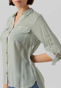 Groen en wit gestreepte button-up shirt met twee borstzakken, een kraag en opgerolde mouwen met knoopaccenten. Lichtgewicht stof.