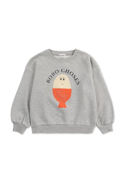 Sudadera gris con cuello redondo, mangas largas abullonadas y un gráfico en naranja y crema de un personaje, que incluye el texto "BOBO CHOSES".