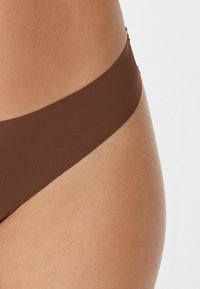 Brązowy dół bikini o gładkiej fakturze i minimalistycznym kroju, z bezszwowym pasem w talii zapewniającym komfort.