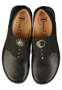 Zwarte leren instapschoenen met decoratieve zon- en cirkelvormige metalen accenten, met een gladde textuur en een ronde neuzenontwerp.
