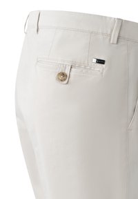 Beige Baumwollhosen zeichnen sich durch eine glatte Textur, eine Gesäßtasche mit Knopfverschluss und ein kleines Markenzeichen in der Nähe des Bundes aus.