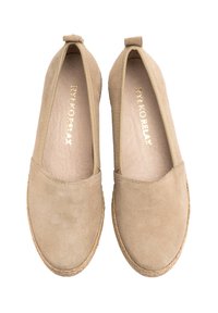 Beige suede slip-on shoes with a flat sole, rounded toe, and a textured surface, featuring a small heel tab for easy wear.