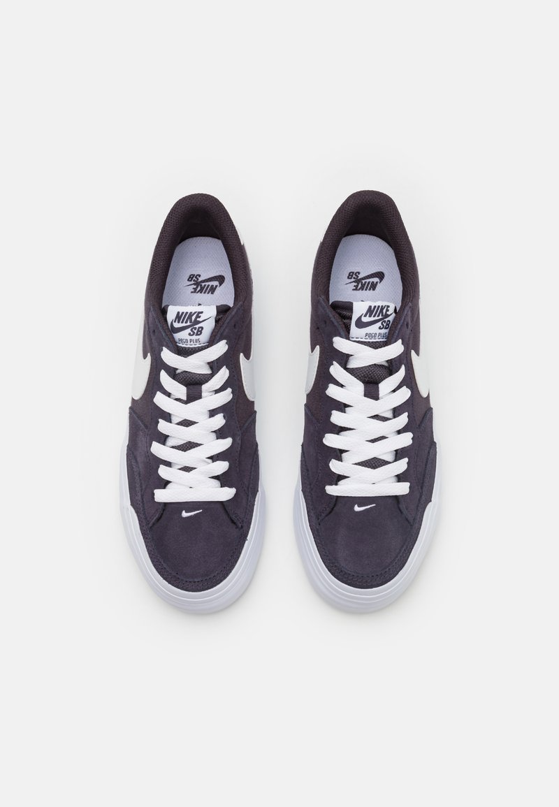 Zapatillas Nike SB en ante azul marino oscuro con cordones blancos, presentando un logo swoosh blanco y una suela de goma blanca, diseño de puntera redonda.