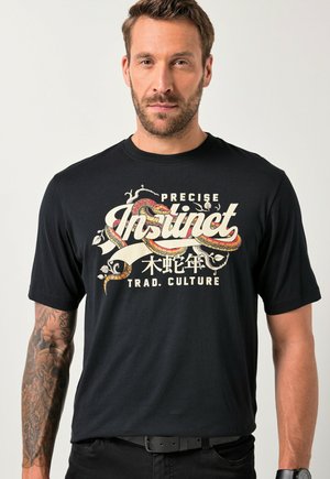 Camiseta de algodón negra con un audaz diseño gráfico multicolor que incluye la palabra "Instinto" y una ilustración de serpiente.