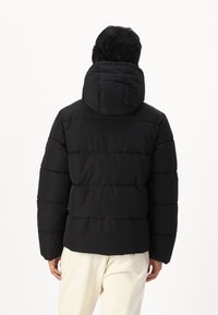 Svart puffjakke med hette, med horisontale quiltede linjer, en glatt tekstur og en tettsittende silhuett. Enkelt design, uten synlige logoer.