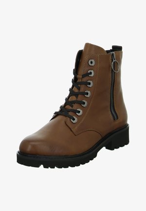 Botte cheville en cuir marron avec des lacets noirs, des œillets en argent et une fermeture éclair sur le côté. Dispose d'une semelle en caoutchouc noir épaisse avec un profil texturé.
