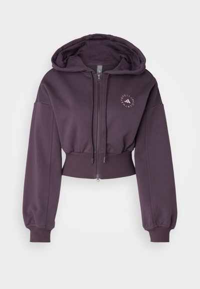 Cropped purple hoodie with zip closure, oversized sleeves, ribbed waist, and a small logo printed on the chest. Soft fabric texture.