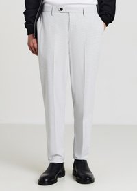 Hellgraue maßgeschneiderte Hosen mit einem strukturierten Muster, geradem Schnitt, einzelnen Falten und einem Knopfverschluss, kombiniert mit schwarzen Knöchelstiefeln.