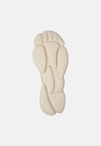Shoe sole in textured off-white material featuring an abstract blob design with varying shapes and sizes, marked with the number 42.