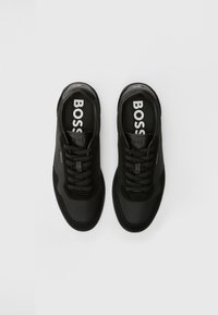Czarne tenisówki z cholewką z siateczki i zamszu, okrągłym noskiem, sznurowanym zapięciem i wyraźnym białym logo „BOSS” na wkładce.