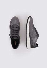 Sneakers grigi fatti di tessuto texturizzato e pelle liscia. Presentano una suola bianca a contrasto e una cerniera laterale per una facile indossabilità.
