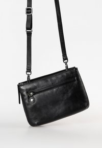 Schwarze Leder-Crossbody-Tasche mit Reißverschluss-Oberseite, Vordertasche und verstellbarem Tragegurt, mit glatter Textur und minimalistischem Design.