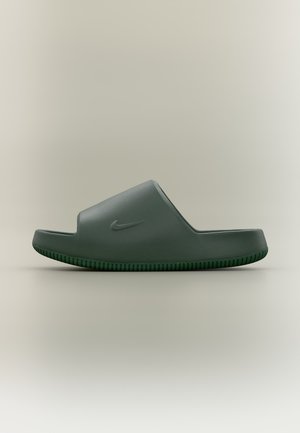 Тъмнозелен слайд сандал Nike с широка затворена лента и текстурирана подметка, показан отстрани на неутрален фон.