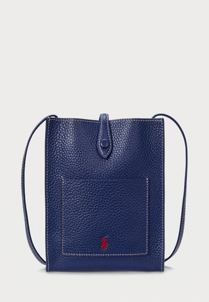 Navy leather crossbody bag with a textured finish, featuring a front pocket and a small red logo. Contrast stitching on the edges.